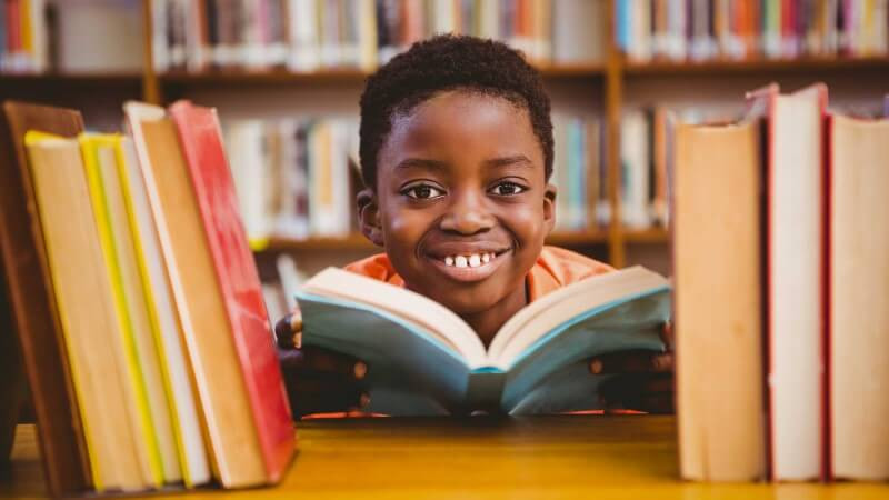 a6dd7a64c9a27112a41b9d34a66cbc32_Cute-boy-reading-book-in-library-2650x1767-2650-1491-c-90-optimized