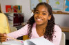 Young-student-at-desk-with-book-smiling-at-camera-1698x1131-300x200