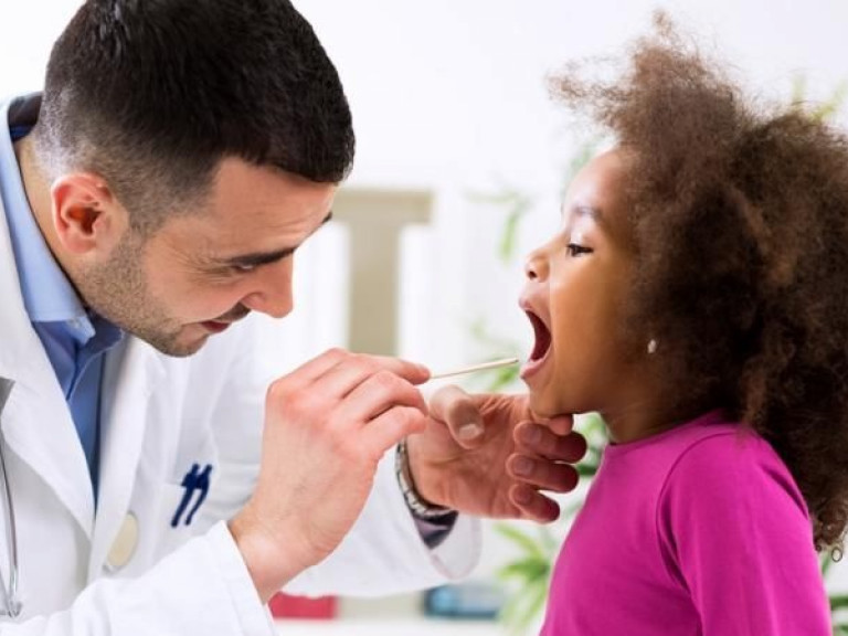 Pediatrician examining young girl