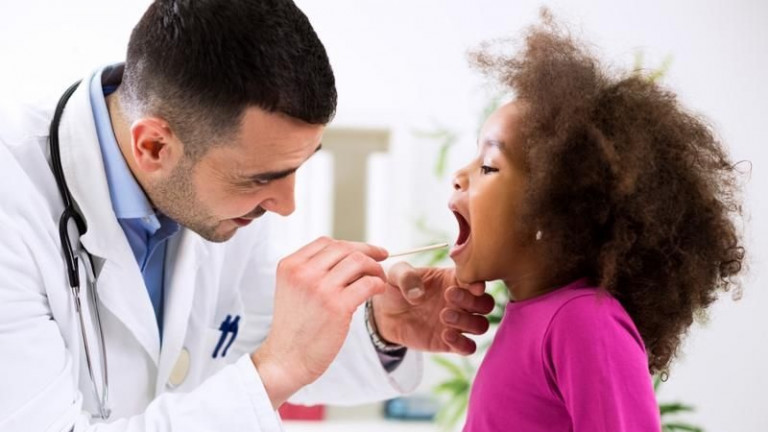 Pediatrician examining young girl