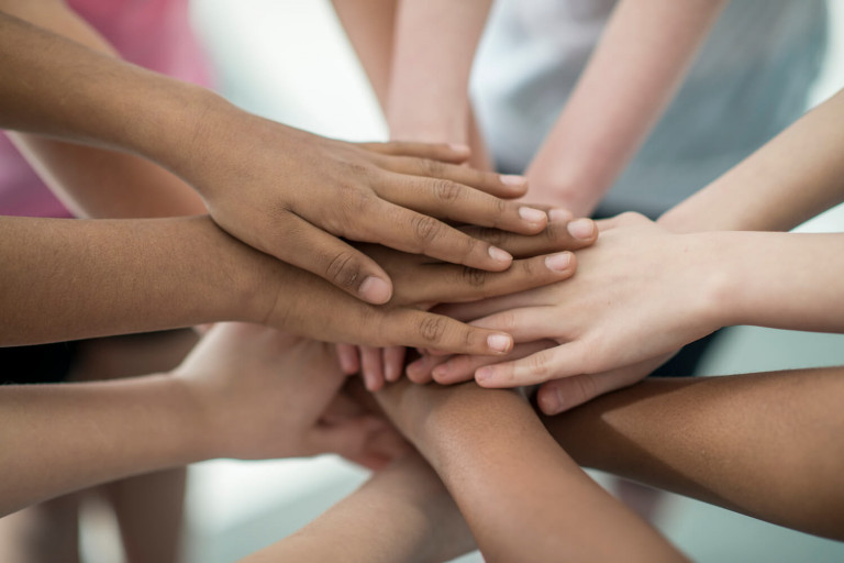 stacked hands in huddle