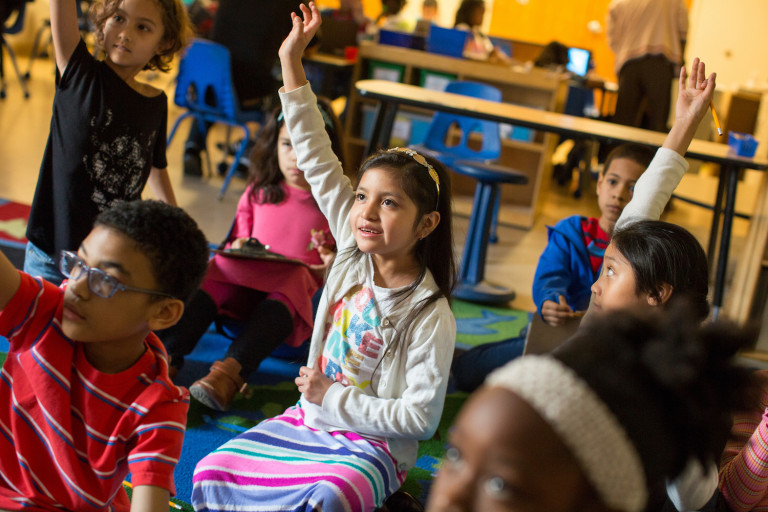 Third-grade girl raises hand